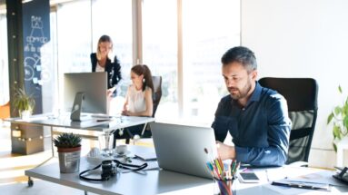 Business people in an office looking at data in computers